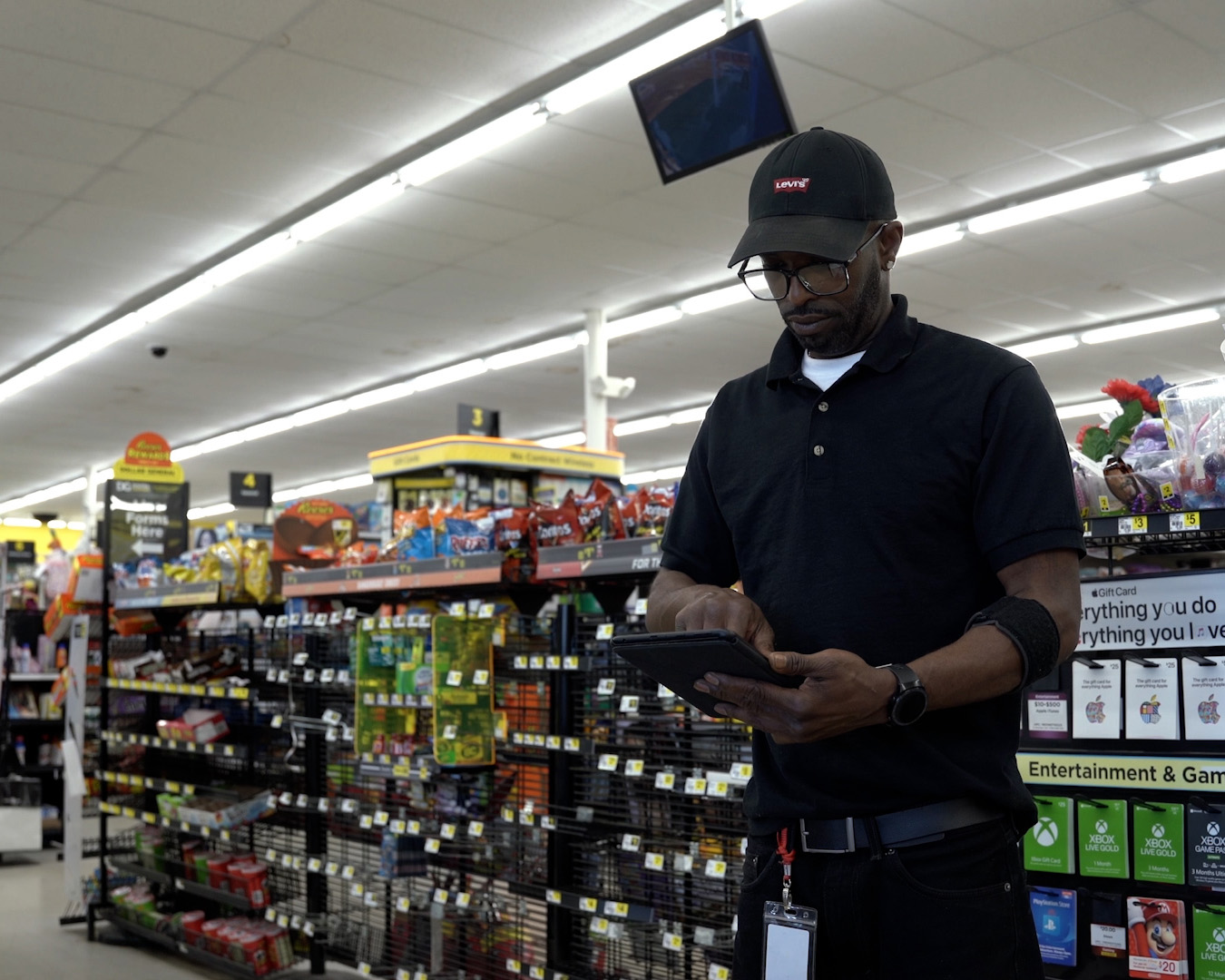 man standing in store holding a tablet